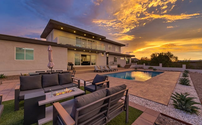 Backyard pool and spa with lounge chairs, palm trees, mountain view, and desert landscape